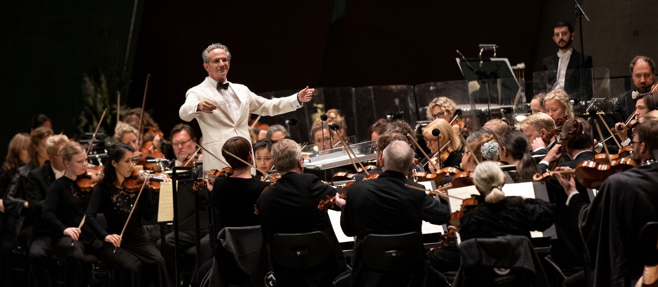 Fabio Luisi i hvidt jakkesæt dirigerer
