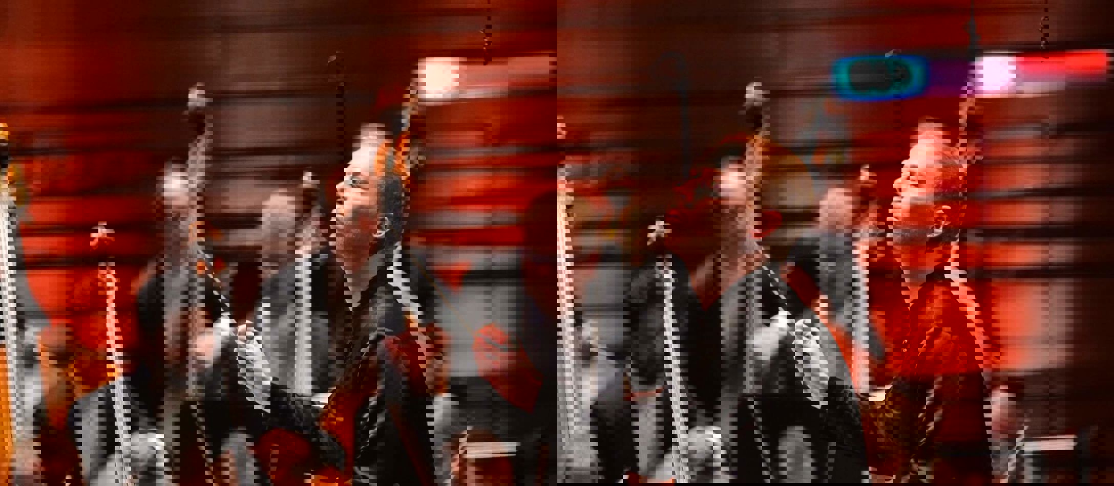 Dmitry Matvienko i profil dirigerer et stort orkester i rød sal