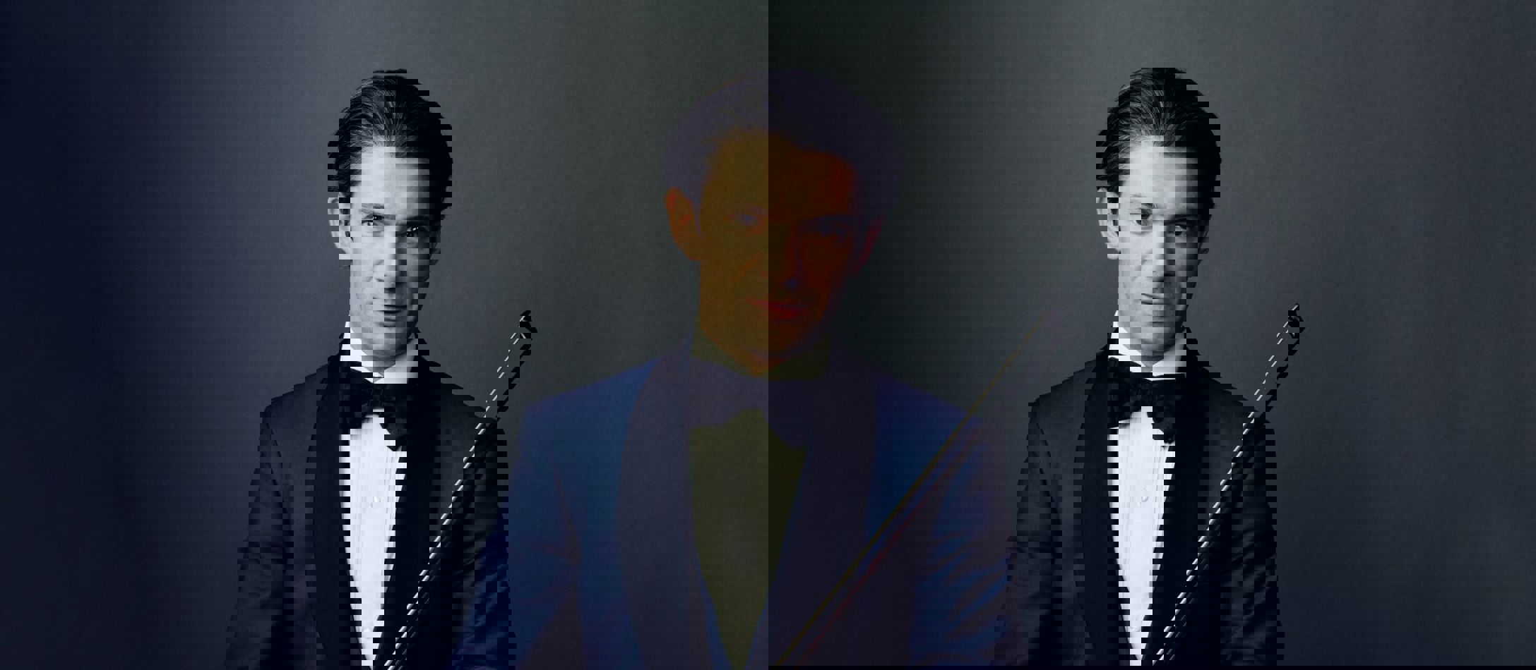 Gautier Capuçon cellostjerne iført hvid skjorte, sort butterfly og blå habitjakke foran mørkeblå baggrund