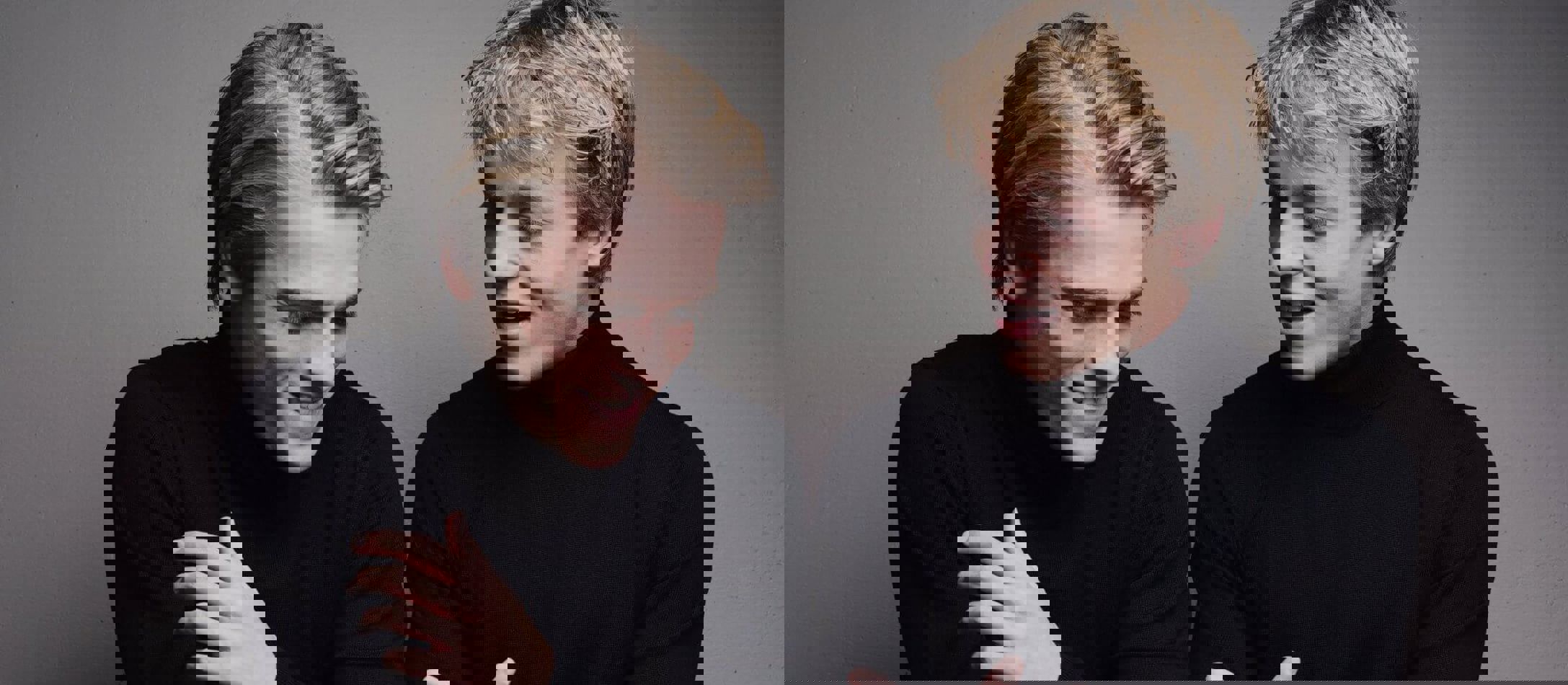 De lyshårede klaverbrødre Lucas & Arthur Jussen begge iført sort halskrave sidder ved reflekterende klaver og smiler til hinanden.